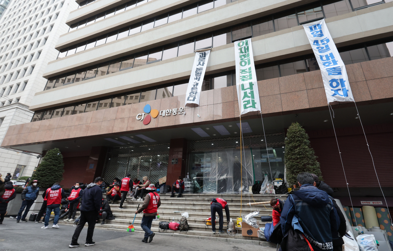 지난 13일 오후 전국택배노동조합 CJ대한통운본부 관계자들이 점거 농성 중인 서울 중구 CJ대한통운 본사에 과로사 방지 이행 촉구 관련 현수막이 걸려 있다. [연합]