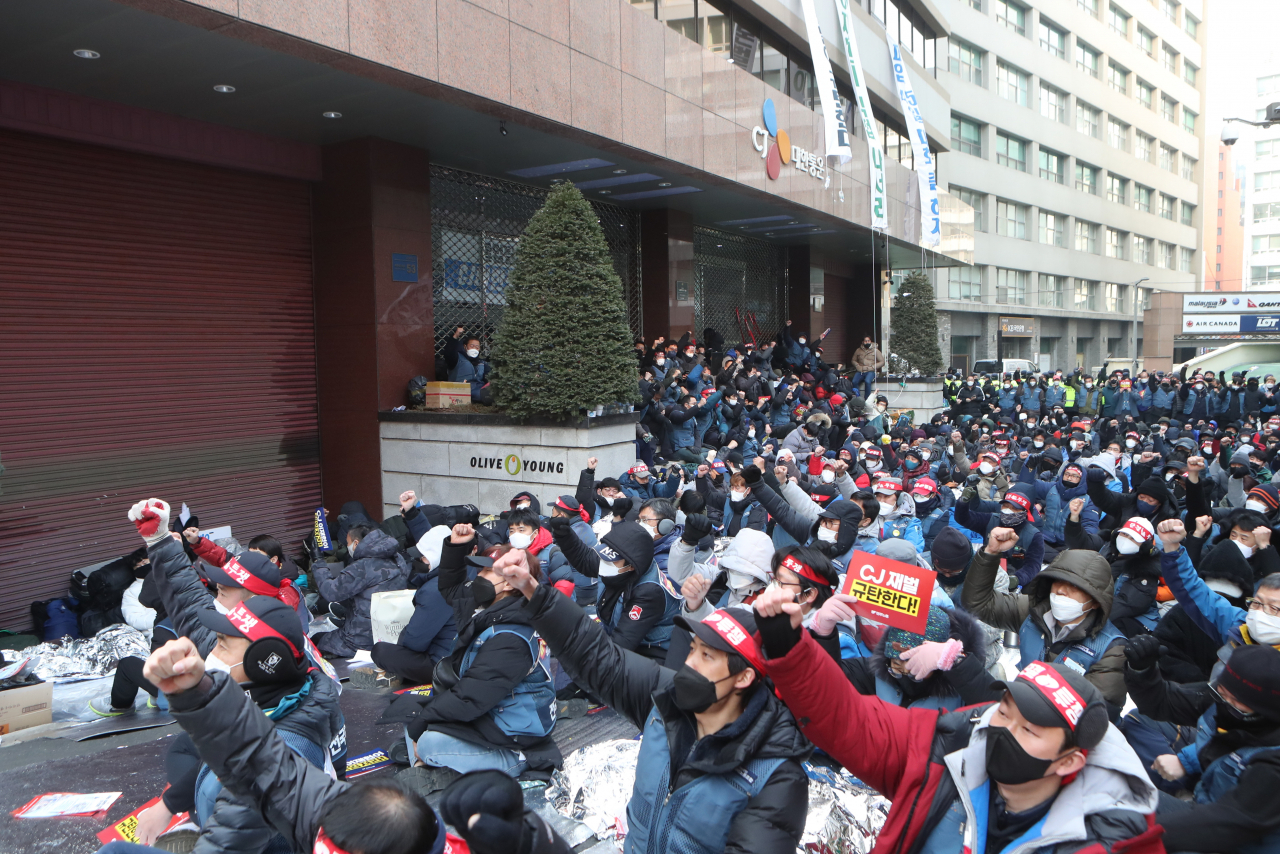 지난 11일 오후 서울 중구 CJ대한통운 본사 앞에서 전국택배노동조합(택배노조)의 조합원들이 구호를 외치고 있다. 파업 중인 택배노조 CJ대한통운노조는 전날 CJ대한통운 본사를 기습 점거하고 농성에 돌입했다. [연합]