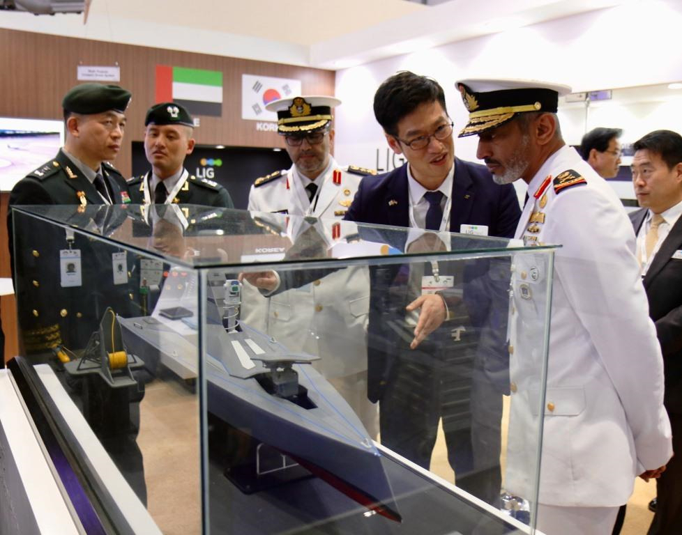 2020년 열렸던 무인·로봇 분야 전시회 UAE UMEX를 방문한 현지 군 관계자에게 LIG넥스원 담당자가 무인수상정 ‘해검’을 소개하고 있다. [LIG넥스원 제공]