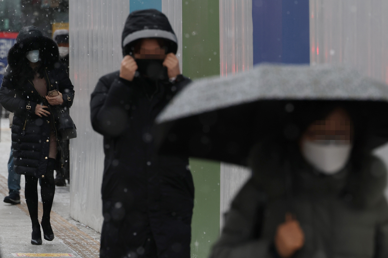정월대보름인 15일 오전 서울 중구 을지로입구역 인근에서 시민들이 눈을 맞으며 걷고 있다. [연합]