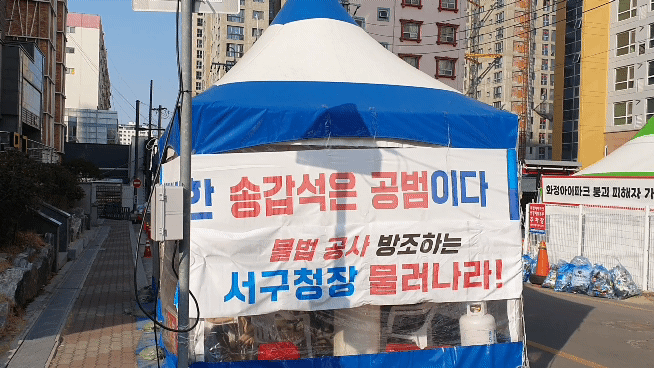 광주화정아이파크 붕괴사고 피해를 입은 상인들이 거리에 천막을 마련하고 피해보상 및 재발방지 대책 등을 요구하고 나섰다. 천막입구에는 기존 정치인에 대한 불신을 표현한 현수막이 게재돼 있다. 서인주 기자