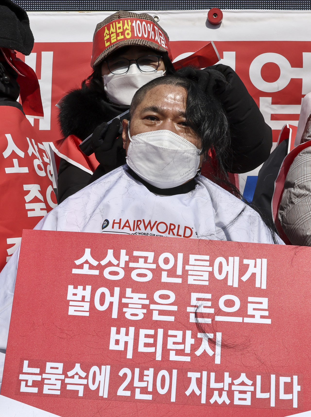15일 오후 서울 광화문 열린마당에서 열린 ‘코로나 피해 실질 보상 촉구 및 정부 규탄대회’에서 자영업자들이 삭발식을 하고 있다. 연합뉴스