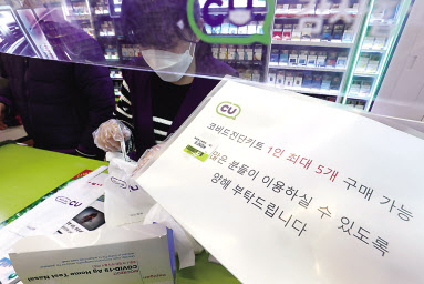 지난 15일 서울 강남구의 한 편의점에서 직원이 일회용 장갑을 끼고 코로나19 자가검사키트를 소분하고 있다. [연합]