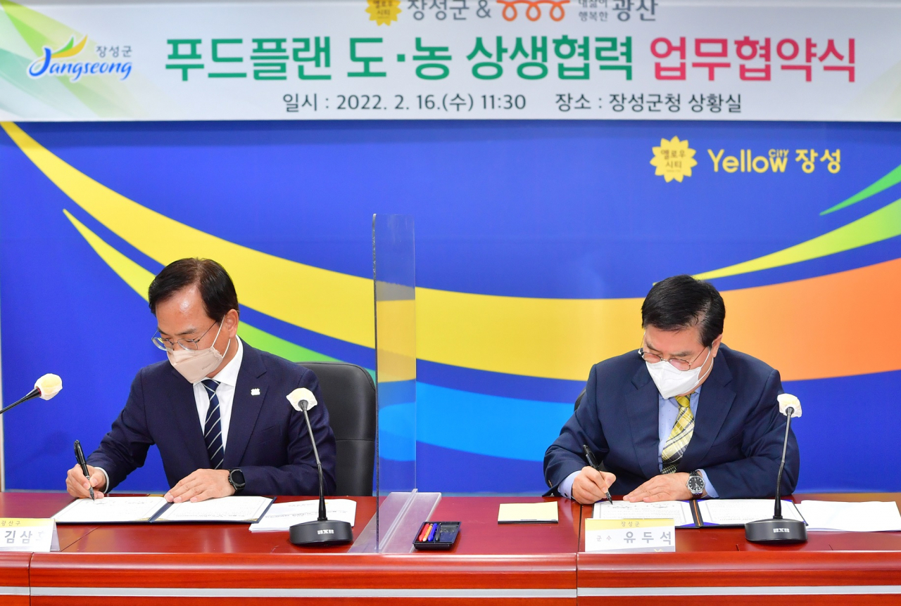 업무협약서에 서명하고 있는 김삼호구청장과 유두석군수