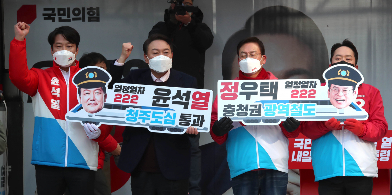 윤석열 국민의힘 대선후보가 16일 오후 충북 청주시 상당구 성안길에서 열린 '충북의 힘 내일을 만드는 대통령!' 청주 거점유세에서 충청권 광역철도 유치 피켓을 들고 지지를 호소하고 있다. [연합]