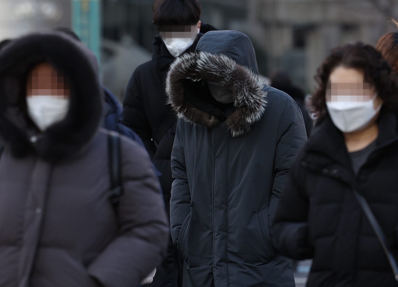 한파가 이어진 지난 16일 오전 서울 종로구 광화문 사거리에서 두꺼운 외투를 입은 시민들이 횡단보도를 건너고 있다. [연합]