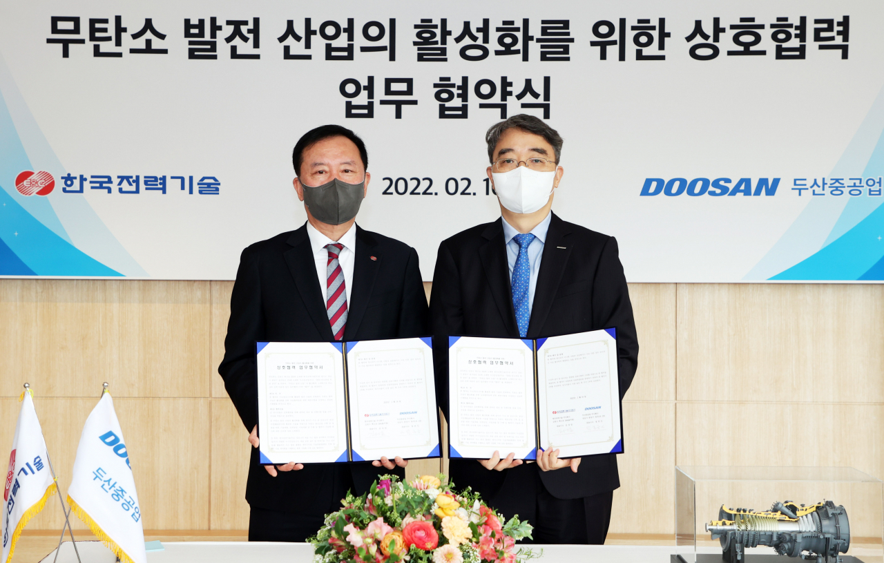 지난 16일 두산중공업 창원 본사에서 열린 협약식에서 김성암(왼쪽) 한국전력기술 사장과 박홍욱 두산중공업 파워서비스 BG장이 협약서 사인 후 기념촬영을 하고 있다. [두산중공업 제공]