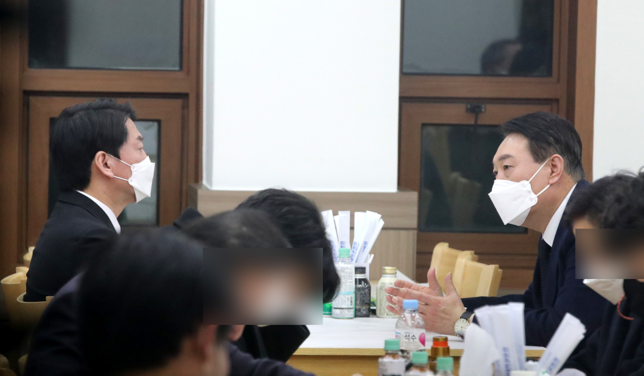 윤석열 국민의힘 대선후보가 지난 16일 저녁 천안 단국대병원에 마련된 고 손평오 국민의당 논산·계룡·금산 지역선대위원장의 빈소를 조문한 뒤 안철수 국민의당 대선후보를 위로하고 있다. [연합]