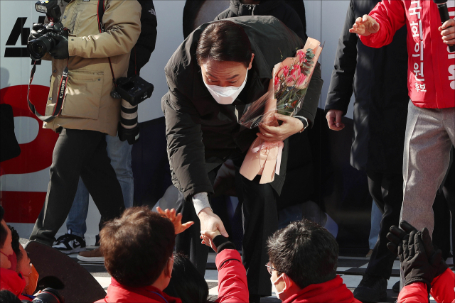 윤석열 국민의힘 대선후보가 대통령선거 20일을 앞둔 17일 오전 경기 안성시 중앙시장 앞 서인사거리에서 열린 유세 현장에서 한 지지자로부터 꽃다발을 받고 있다. [국회사진기자단]
