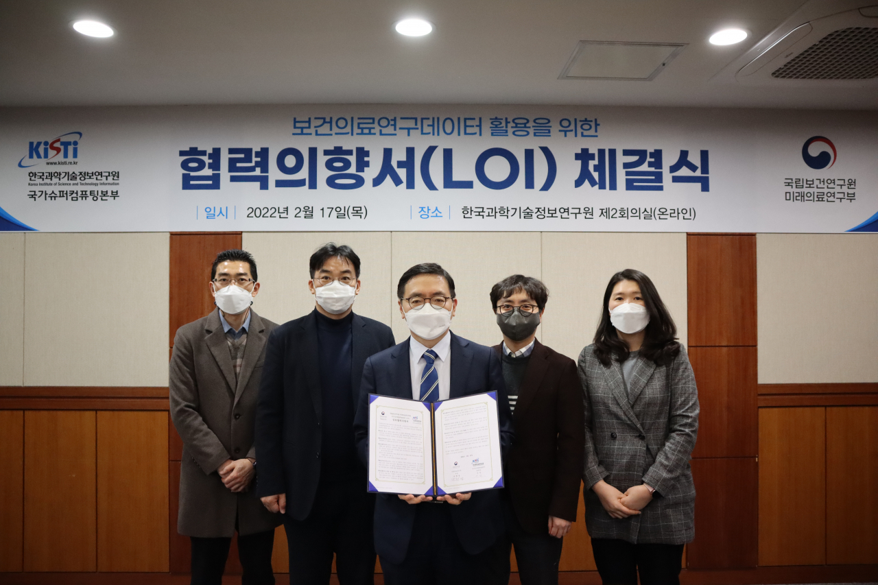 이식(가운데) KISTI 국가슈퍼컴퓨팅본부장이 국립보건연구원과 체결한 협력의향서를 들어보이고 있다.[KISTI 제공]