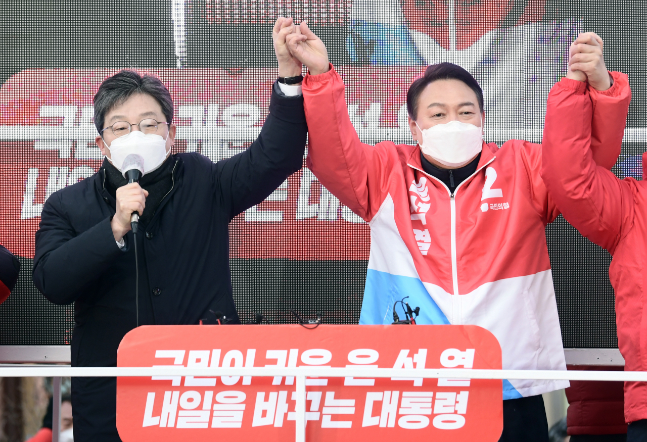 윤석열 국민의힘 대선 후보(오른쪽)가 17일 서울 종로구 동묘앞역에서 열린 "나라를 바로 세웁시다" 종로 유세에서 유승민 전 의원(왼쪽)과 손을 맞잡아 들어 올리며 지지를 호소하고 있다. [연합]