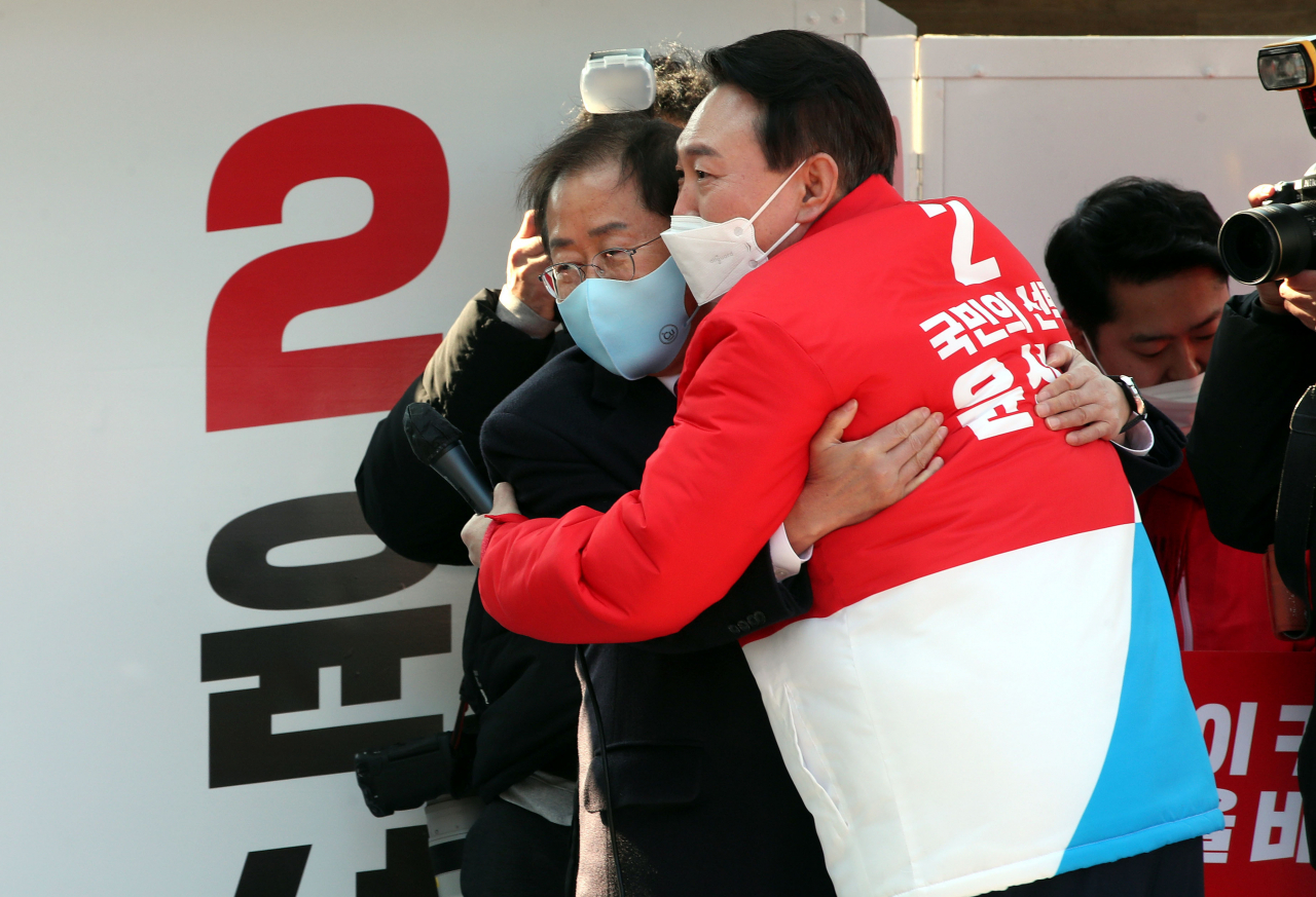 윤석열 국민의힘 대선 후보가 지난 15일 오후 대구 동구 동대구역 광장에서 열린 거점 유세에서 지지 연설을 마친 홍준표 선대본 상임고문과 포옹하고 있다. [연합]
