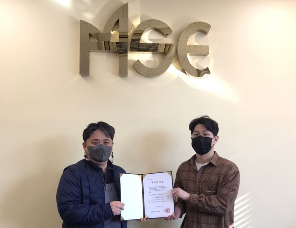 울산과학기술원(UNIST) 신소재공학과 장충현(오른쪽) 학생이 ‘2022년 재료분야 우수논문상’을 수상하고 있는 모습.[한국재료연구원 제공]