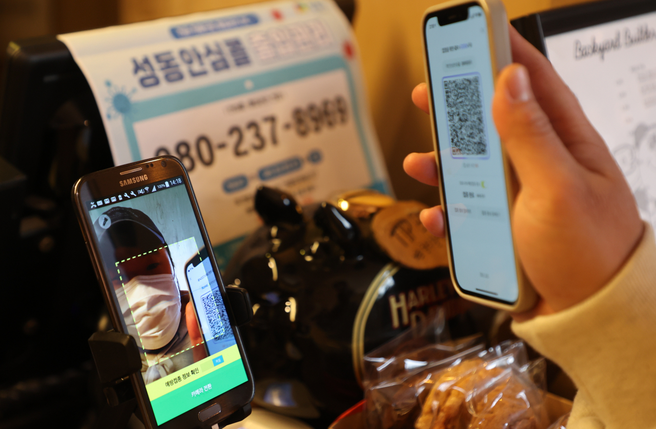 서울 시내 카페에서 방문 고객이 전자출입명부 QR코드를 태그하는 모습. [연합]