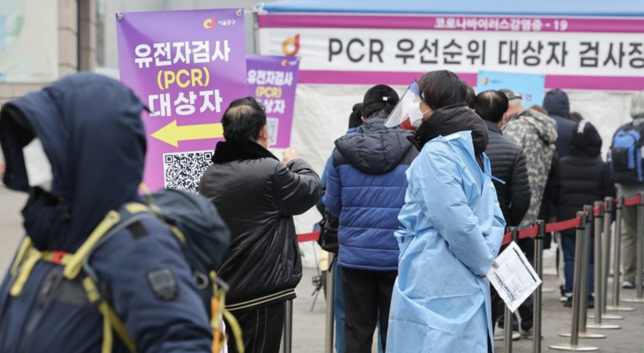 로나19 신규확진자가 이틀째 10만 명을 넘어선 19일 오전 서울 중구 서울역 광장에 마련된 임시선별검사소에서 시민들이 줄을 서서 검사 순서를 기다리고 있다. [연합]