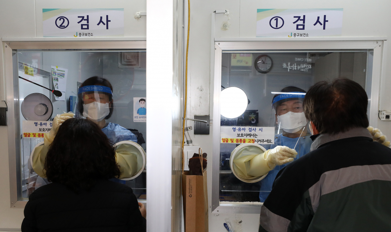 안철수 국민의당 대선 후보(오른쪽)와 부인 김미경 교수가 19일 오전 서울 중구보건소 선별진료소에서 코로나19 검체 채취 의료 자원봉사를 하고 있다. [연합]