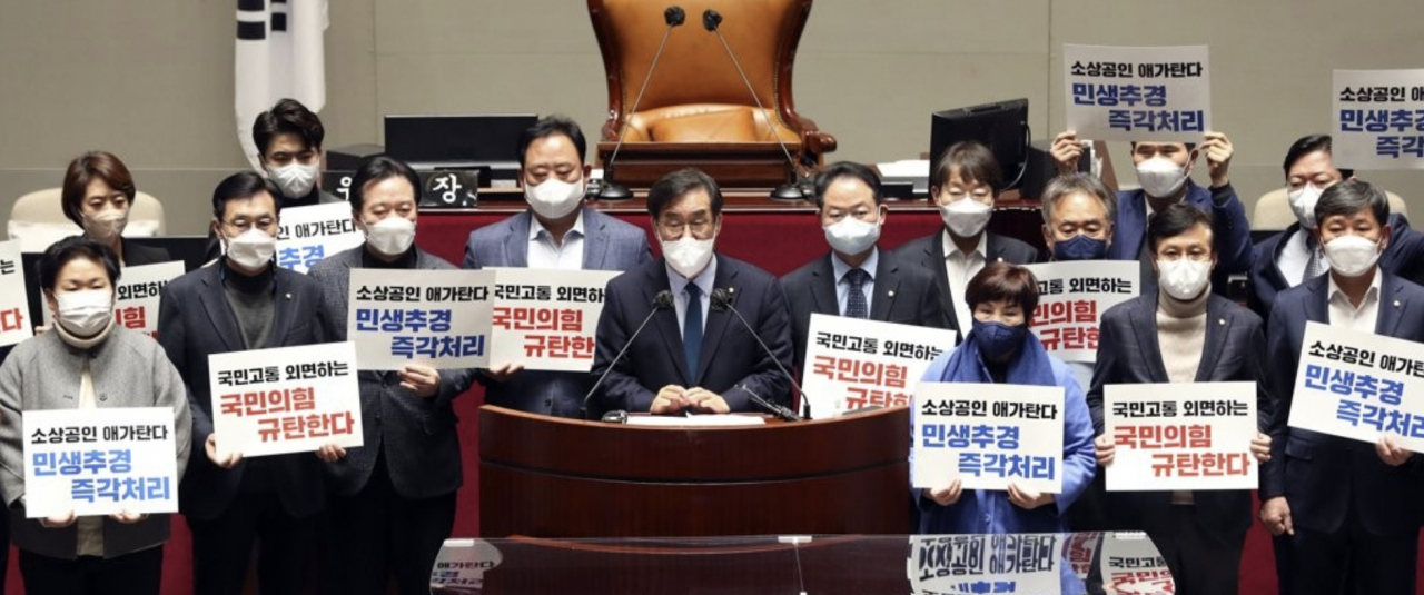 더불어민주당 국회 예결위원들이 18일 오후 서울 여의도 국회 예결위회의장에서 추경 처리 촉구 피켓을 들고 긴급 기자회견을 하고 있다. 결국 더불어민주당은 19일 새벽 단독으로 추경안을 기습 처리했다. [연합]