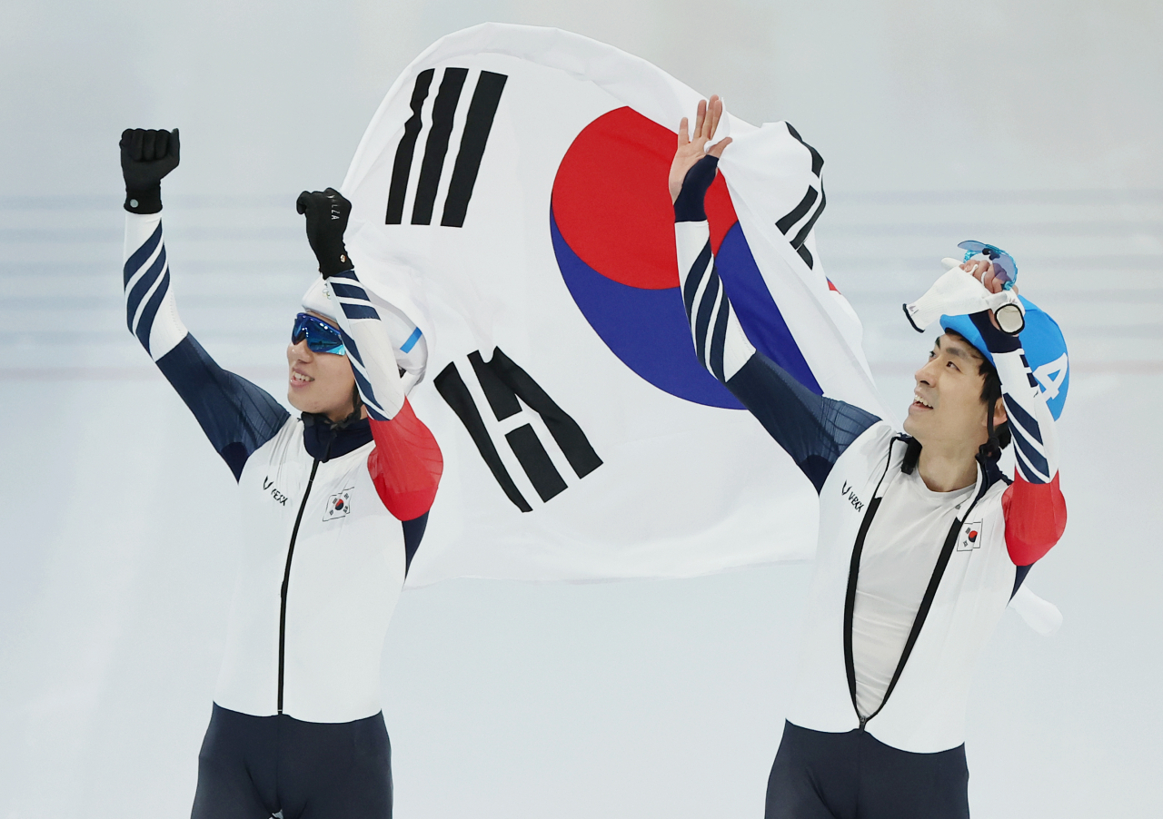 정재원(왼쪽)과 이승훈이 19일 중국 베이징 국립 스피드스케이팅 경기장에서 열린 2022 베이징 동계올림픽 스피드스케이팅 남자 매스스타트 결승에서 각각 은메달과 동메달을 획득한 뒤 함께 태극기를 들고 관중석을 향해 인사하고 있다. [연합뉴스]