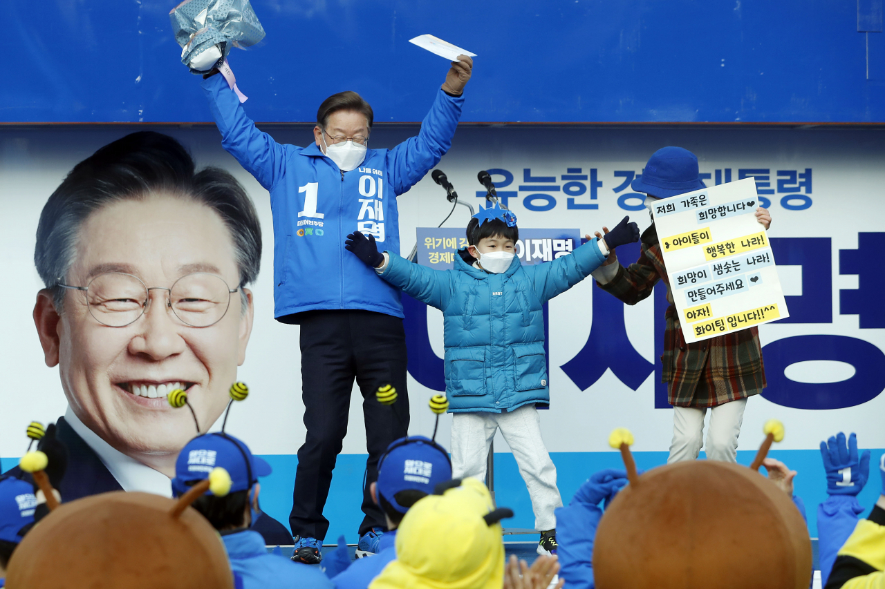 이재명 더불어민주당 대선후보가 19일 경기도 화성시 동탄센트럴파크에서 열린 집중 유세에서 어린이로부터 꽃다발과 희망 편지를 받고 함께 춤을 추고 있다. [연합뉴스]
