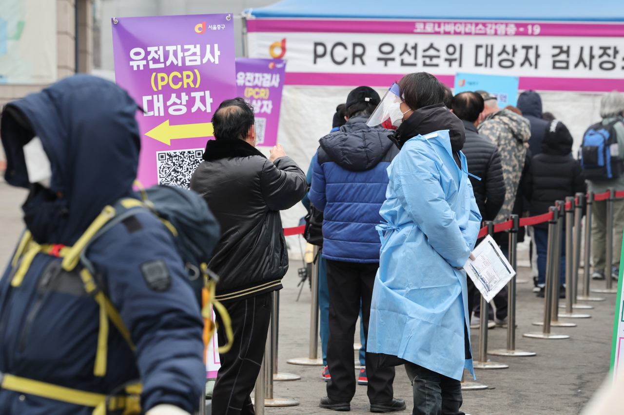 코로나19 신규확진자가 이틀째 10만 명을 넘어선 19일 오전 서울 중구 서울역 광장에 마련된 임시선별검사소에서 시민들이 줄을 서서 검사 순서를 기다리고 있다. [연합뉴스]