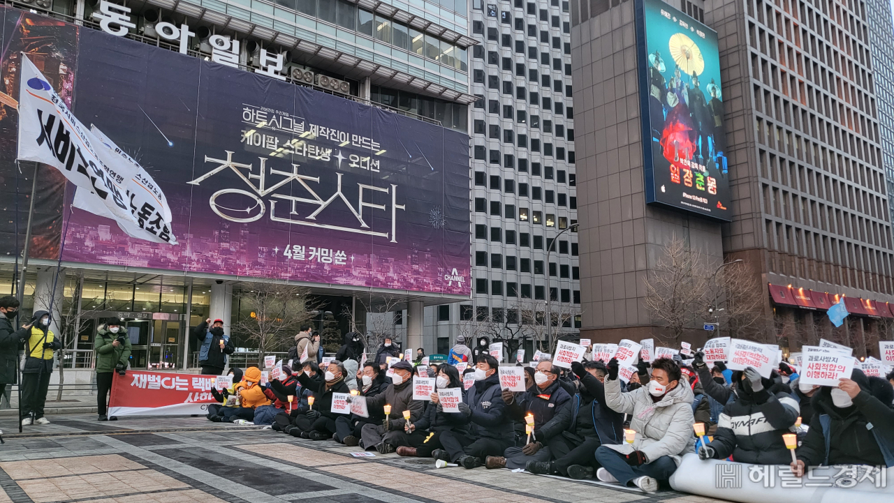 CJ대한통운의 사회적 합의를 촉구하기 위해 결성된 CJ택배 공동대책위원회와 택배노조가 19일 오후 서울 중구 청계광장에서 촛불집회를 열었다. 참가자들이 손팻말을 들고 구호를 외치고 있다. 강승연 기자