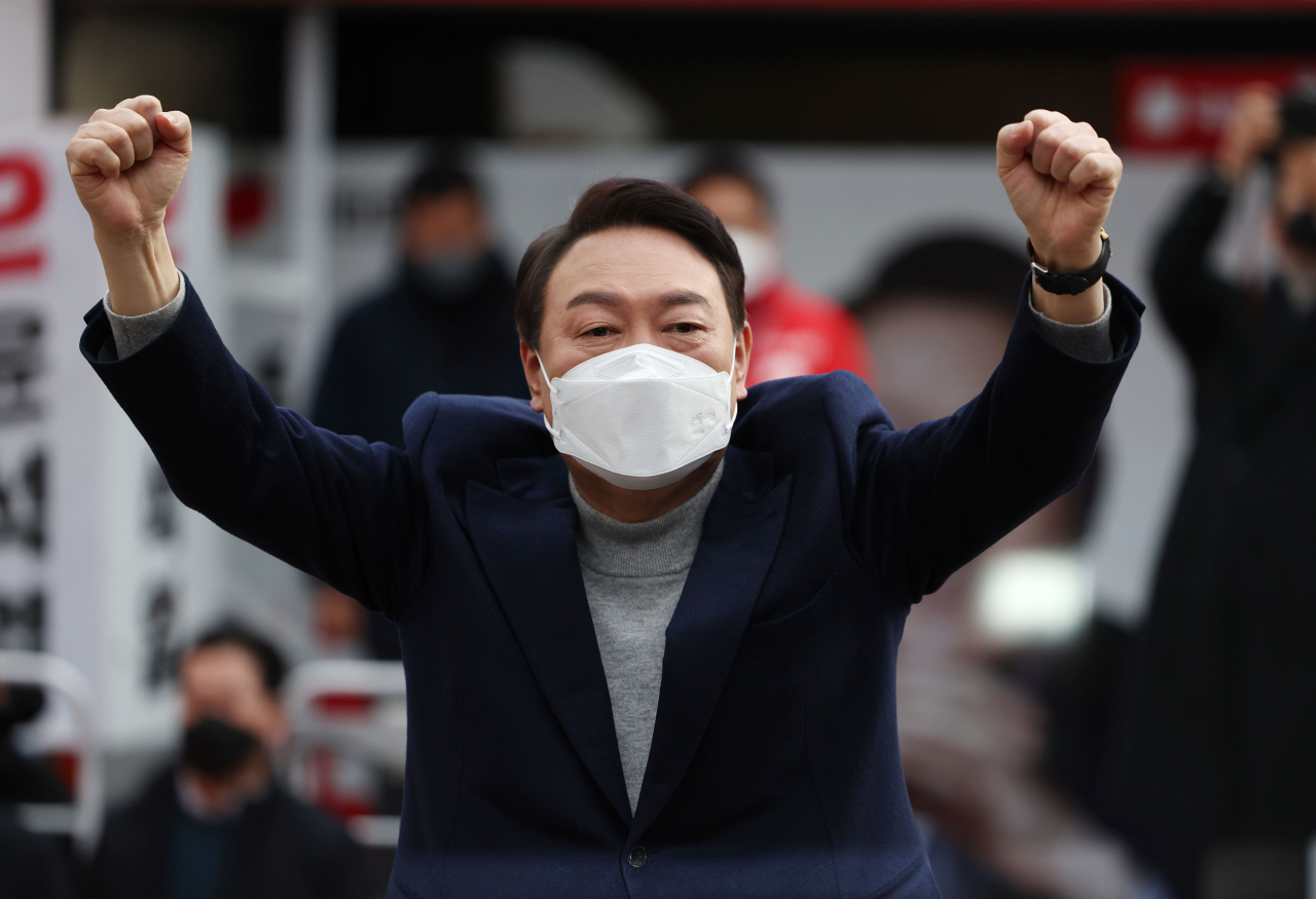 윤석열 국민의힘 대선후보가 19일 오전 울산 롯데백화점 울산점 앞에서 열린 유세에서 두 주먹을 쥔 채 지지자들에게 인사하고 있다. [연합]