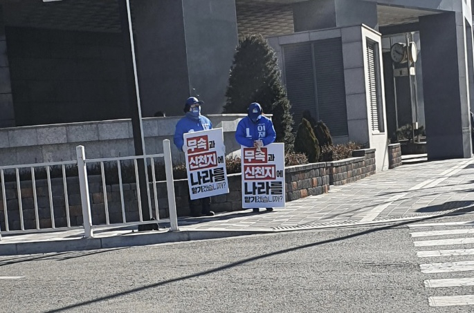 20일 오전 경기도 안양시의 한 교회 근처에서 민주당 선거운동원 두 명이 ‘무속과 신천지에 나라를 맡기겠습니까?’라는 문구가 적힌 손피켓을 들고 선거운동을 하고 있다.