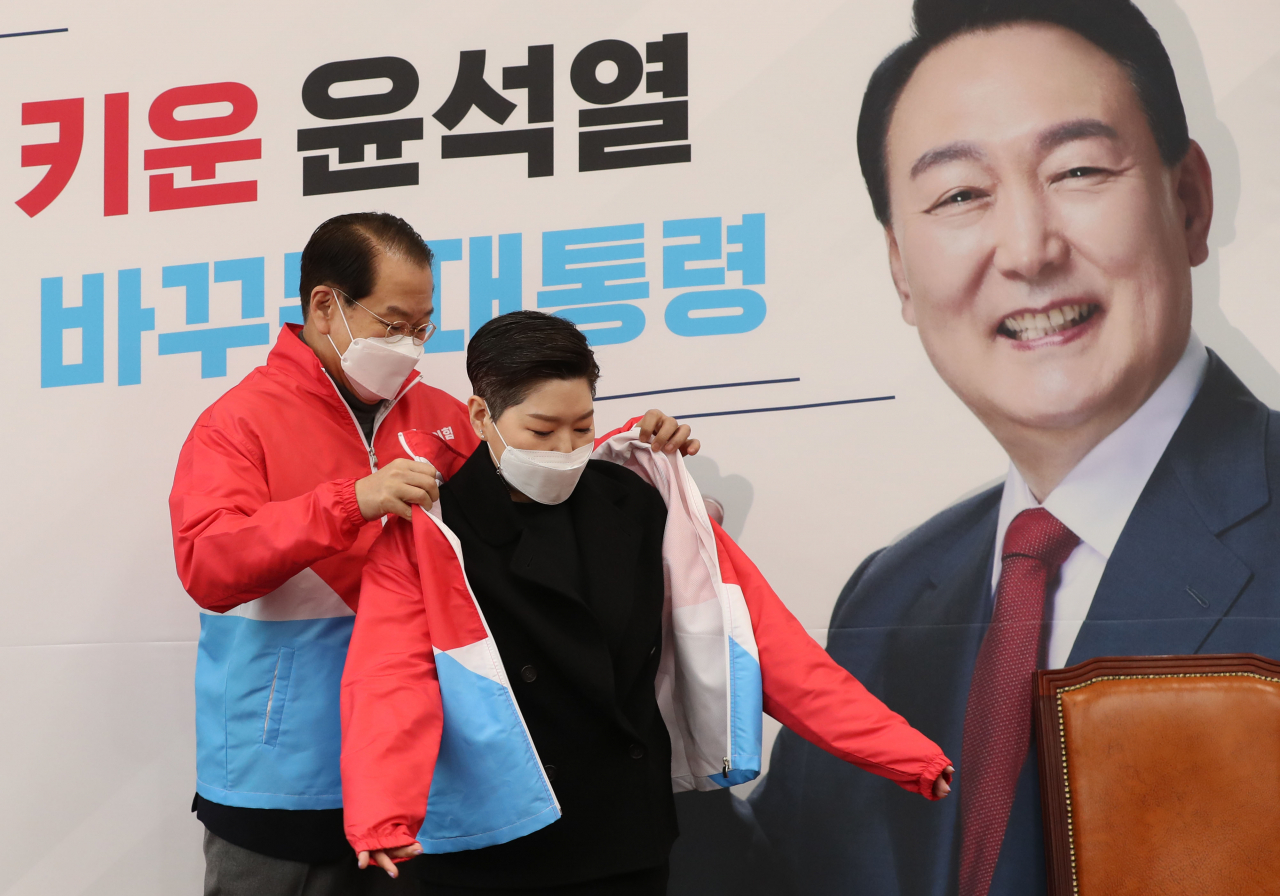 권영세 국민의힘 선거대책본부장이 21일 오전 국회에서 열린 백범 김구 선생 증손 김영 순천향대학교 의료아이티공학과 연구교수 입당식에서 김 교수에게 당 점퍼를 입혀주고 있다. [헤럴드경제=이상섭 기자]