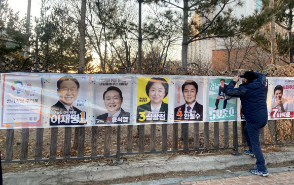 안철수 국민의당 대선 후보의 벽보가 누락된 채 설치된 대구 동구 선거 벽보. 직원이 선거 벽보 수정 작업을 진행중이다. [연합]