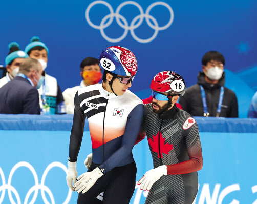 대한민국 쇼트트랙 대표팀 황대헌이 13일 중국 베이징 캐피털 실내 경기장에서 열린 2022 베이징 동계올림픽 쇼트트랙 남자 500m 준결승 2조 경기를 마친 뒤 경기 도중 충돌한 캐나다 스티븐 뒤부아와 대화를 나누고 있다. [연합]