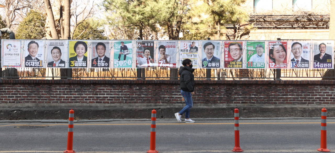 지난 20일 서울 종로구 대학로에 부착된 제20대 대통령 선거 벽보 앞을 한 시민이 지나가고 있다(사진은 기사 내용과 관련없음). [연합]
