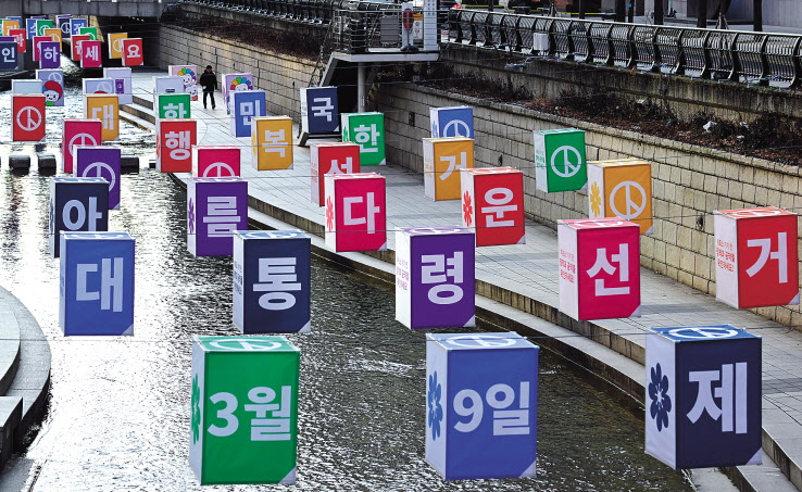 대한민국의 향후 5년을 좌우할 운명의 날이 16일 앞으로 다가왔다. 서울시선거관리위원회가 3월 9일 실시하는 제20대 대통령선거 홍보를 위해 청계천 모전교와 광통교 구간에 ‘아름다운 선거 조형물’을 설치한 가운데 21일 오전 한 시민이 바쁜 발걸음을 옮기고 있다. 박해묵 기자