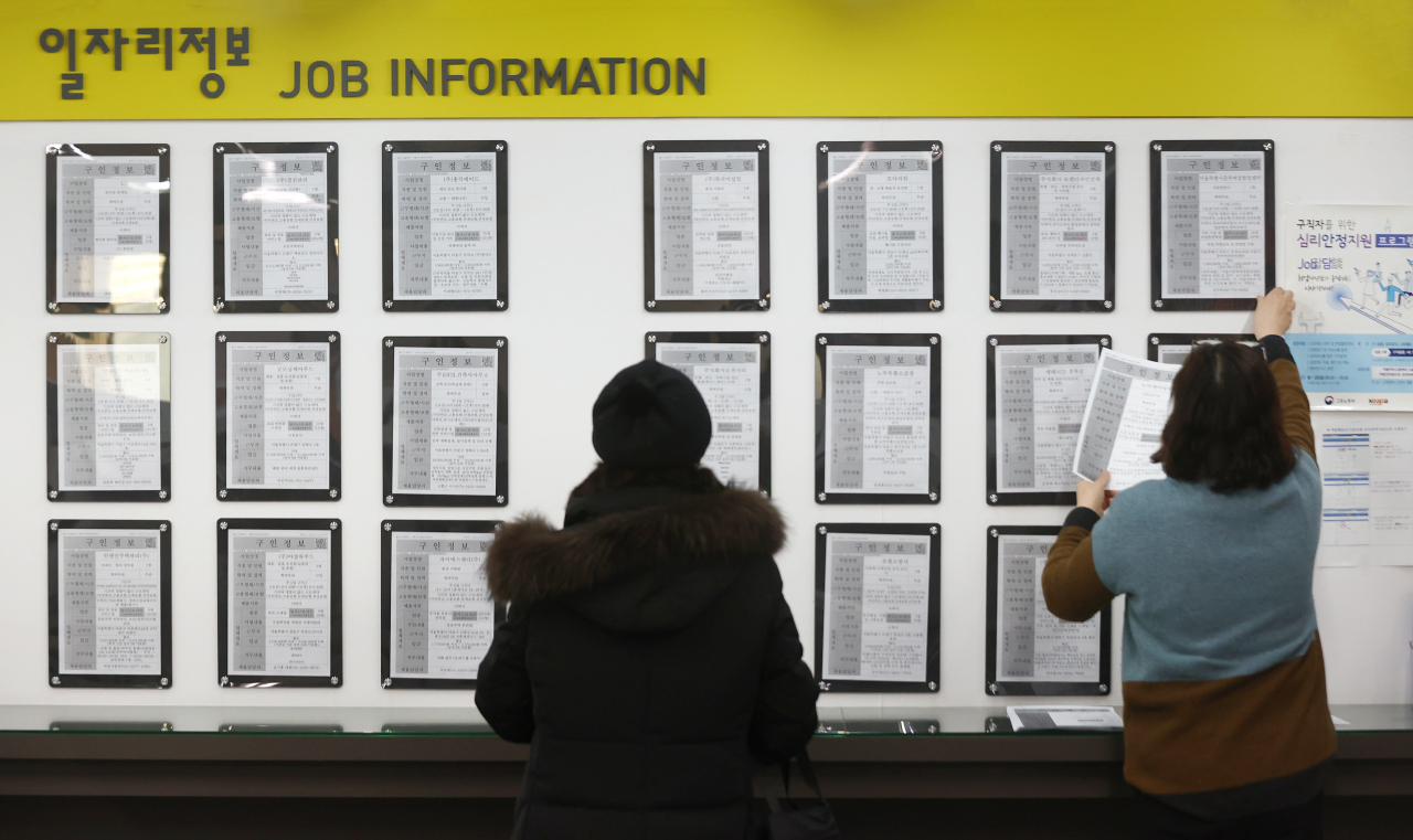 This undated file photo shows job seekers looking at employment information at a job arrangement facility in Seoul. (Yonhap)