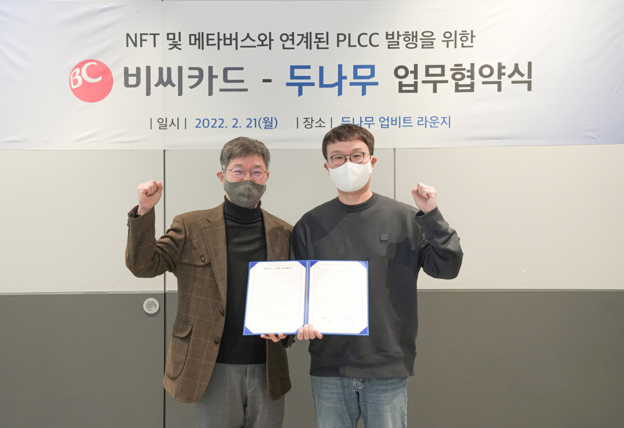 21일 서울 강남구에 위치한 두나무 본사 ’업비트 라운지’에서 열린 협약식에서 최원석 BC카드 사장(왼쪽)과 김형년 두나무 부회장(오른쪽)이 업무협약 체결 이후 기념사진을 촬영 하고 있다.[BC카드 제공]