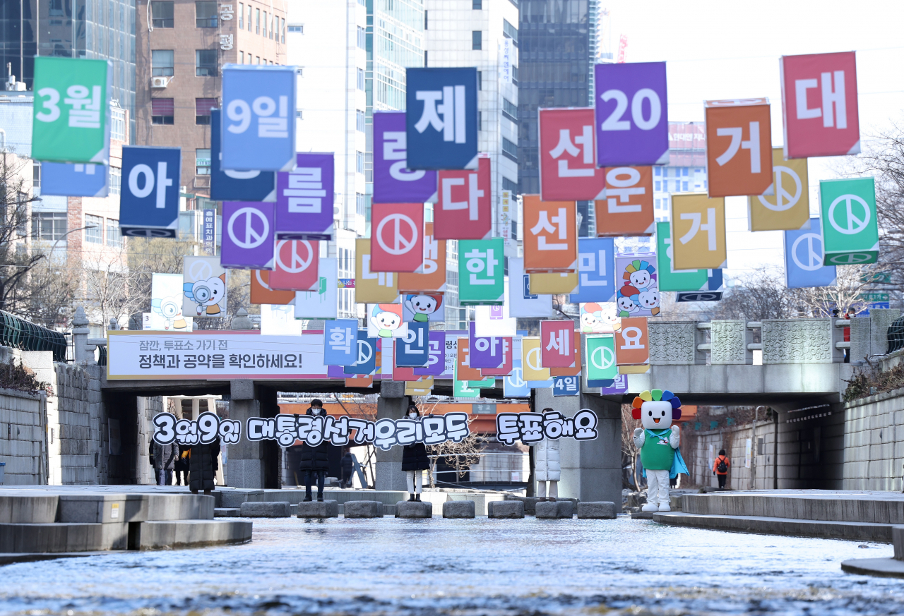 21일 오후 서울 청계천에서 선거관리위원회 직원들이 제20대 대통령선거 투표를 독려하고 있다. [연합]