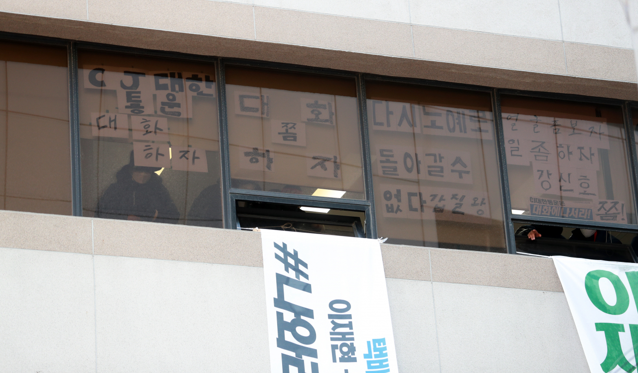 21일 오후 서울 중구 CJ대한통운 본사 3층에서 점거 농성을 펼치고 있는 민주노총 전국택배노동조합(택배노조) 조합원이 창문 밖을 바라보고 있다. [연합]