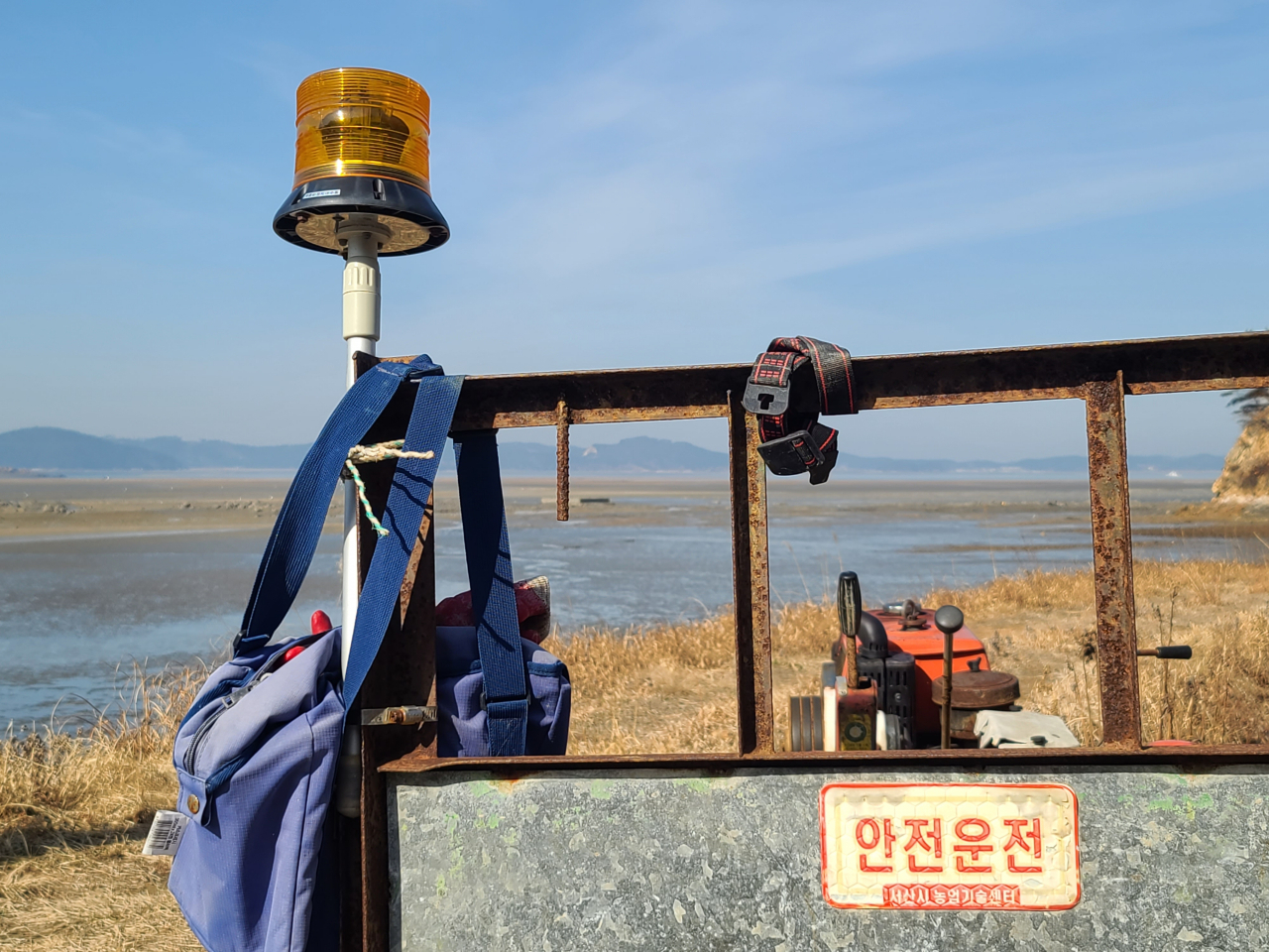 갯벌 옆에서 출격대기중인 서산 오지리 고창개 머드맥스 경운기엔 경광등도 달리고 어로작업,수리 도구 일체가 담긴 가방도 늘 걸려 있다.