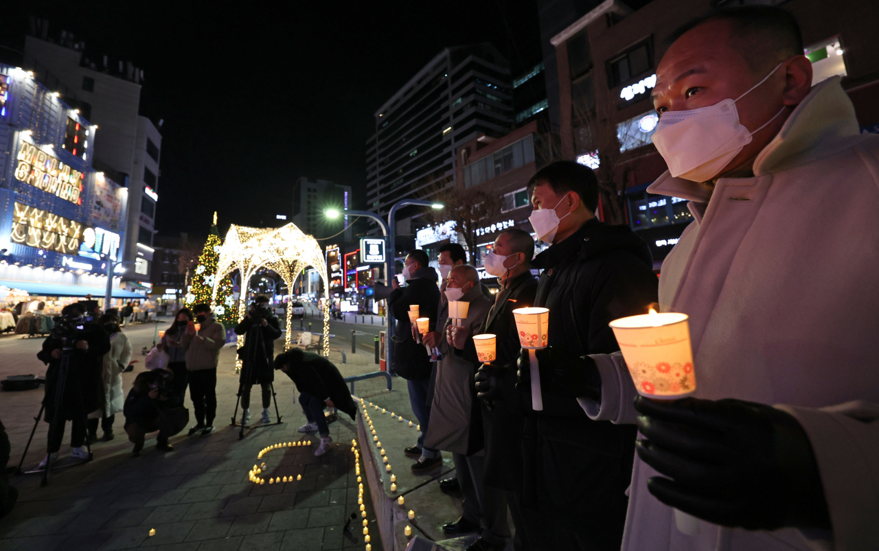 지난 21일 오후 10시께 서울 마포구 홍대입구역 인근에서 코로나피해자영업총연합(코자총) 관계자들이 영업시간 제한 철폐와 자영업자 손실보상을 요구하며 촛불문화행사를 열고 있다. [연합]