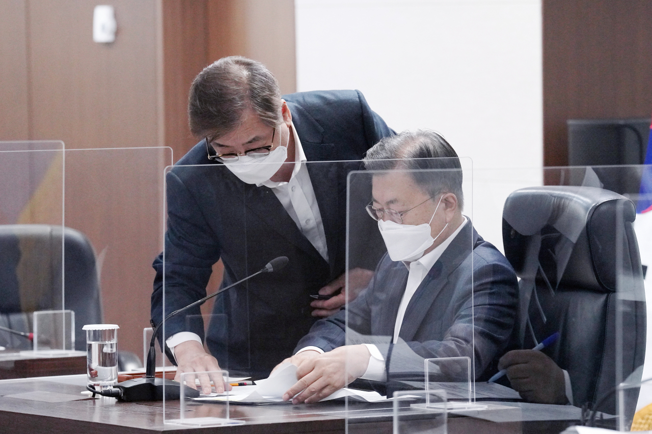 문재인 대통령이 22일 청와대 국가위기관리센터에서 열린 국가안전보장회의 및 대외경제안보전략회의 연석회의에서 서훈 국가안보실장과 자료를 보며 대화하고 있다. [연합]