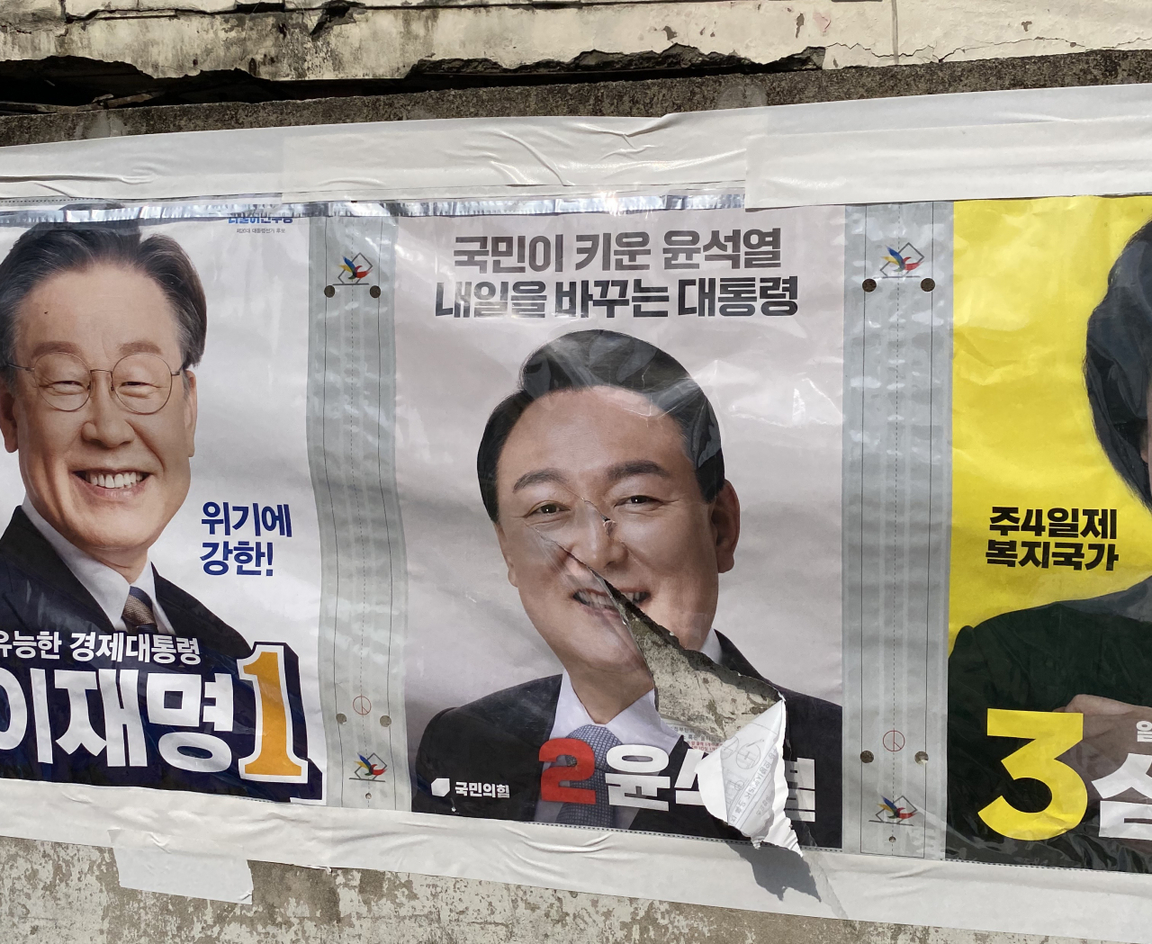 21일 오후 1시께 전북 전주시 덕진구 한 도롯가에 내건 국민의힘 윤석열 대선 후보의 벽보가 훼손된 모습. [연합]