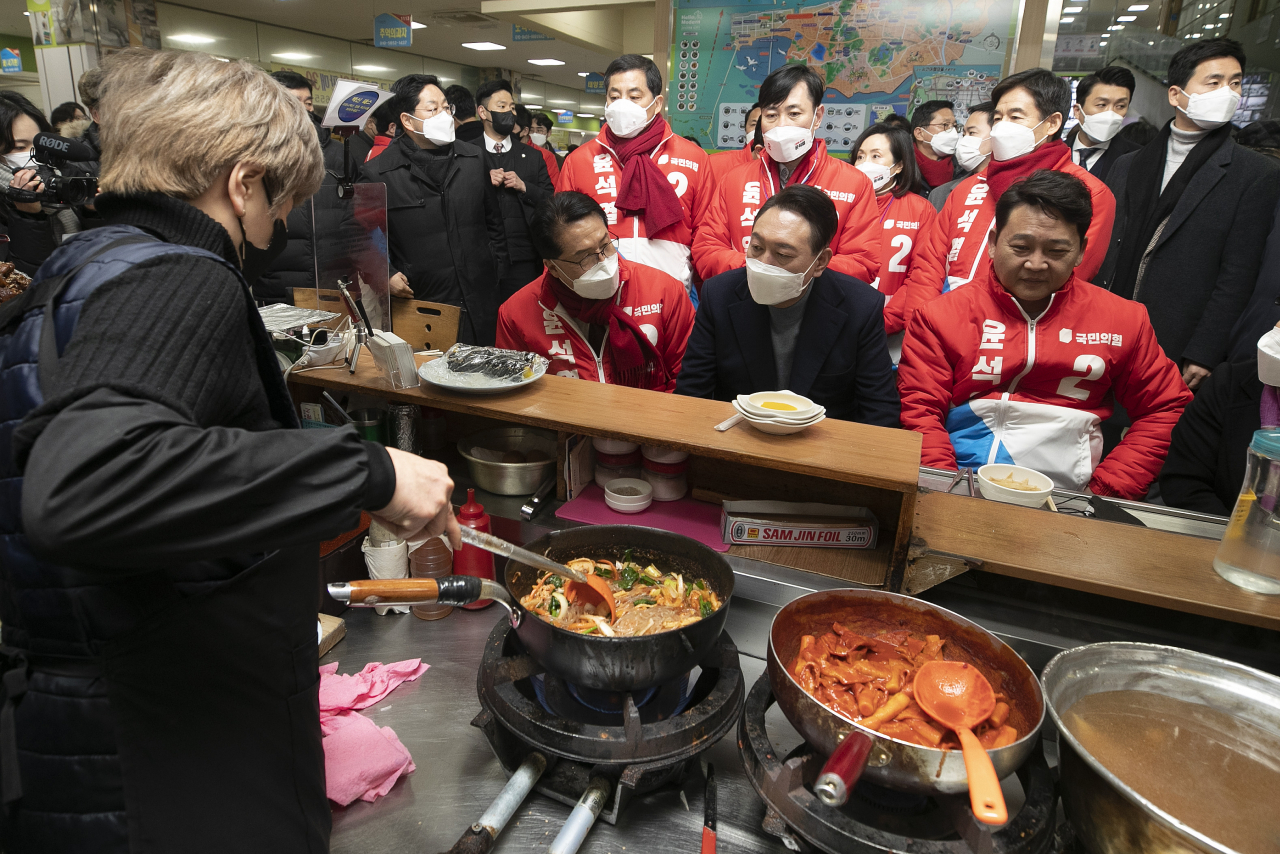 윤석열 국민의힘 대선 후보가 22일 오후 전북 군산시 군산공설시장 한 음식점에서 매운 잡채를 시킨 후 요리가 완성되기를 기다리고 있다. [연합]