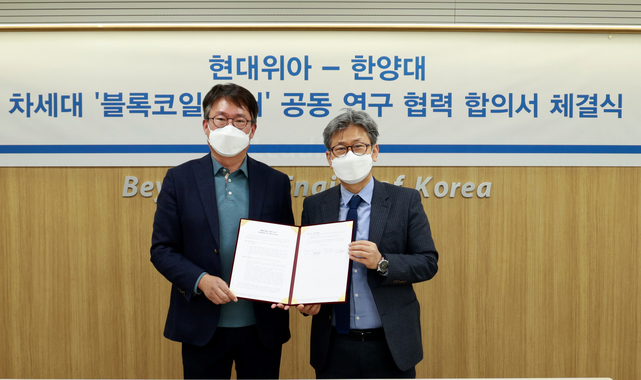 현대위아 차량부품연구센터장 원광민 상무(왼쪽)와 한양대 이주 교수가 지난 22일 서울 성동구 한양대학교에서 '블록코일을 적용한 모터 사업 협력을 위한 합의서(MOA)'를 체결하고 기념 사진을 찍고 있다. [현대위아 제공]
