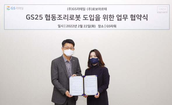 지난 22일 GS타워 지하1층 식품개발팀 회의실에서 권영환(왼쪽) GS리테일 간편식품부문장과 강지영 로보아르테 대표이사가 업무협약을 맺고 기념촬영을 하고 있다.[GS리테일 제공]
