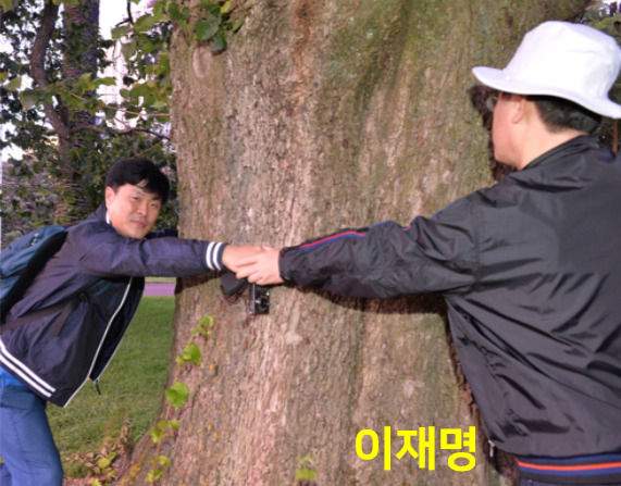 김문기(왼쪽) 성남도시개발공사 개발1처장과 이재명 더불어민주당 대선후보가 지난 2015년 1월 7일 뉴질랜드 오클랜드 알버트 공원에서 손을 맞잡고 찍은 사진. [국민의힘 제공]