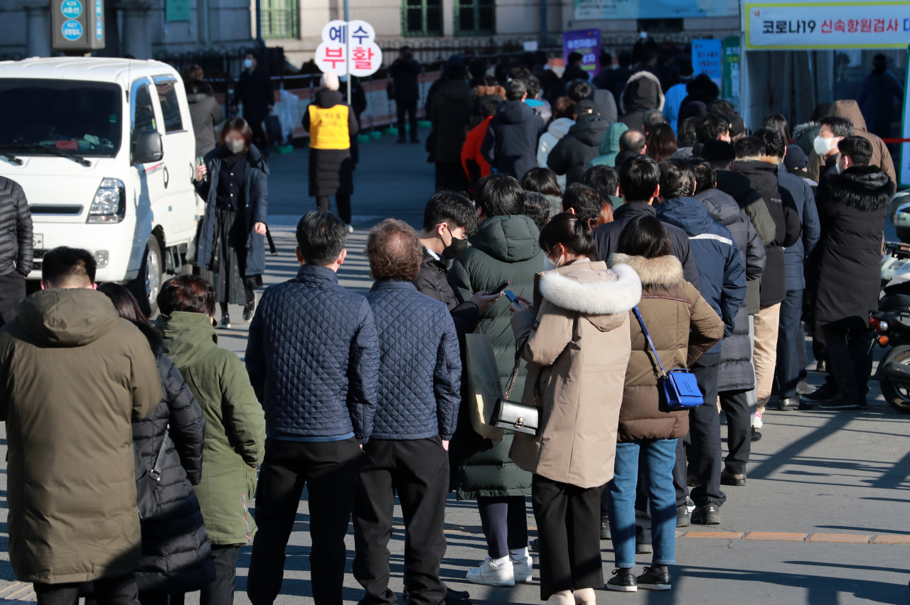 People wait in line to receive COVID-19 tests at a makeshift testing station in Seoul on Thursday. (Yonhap)