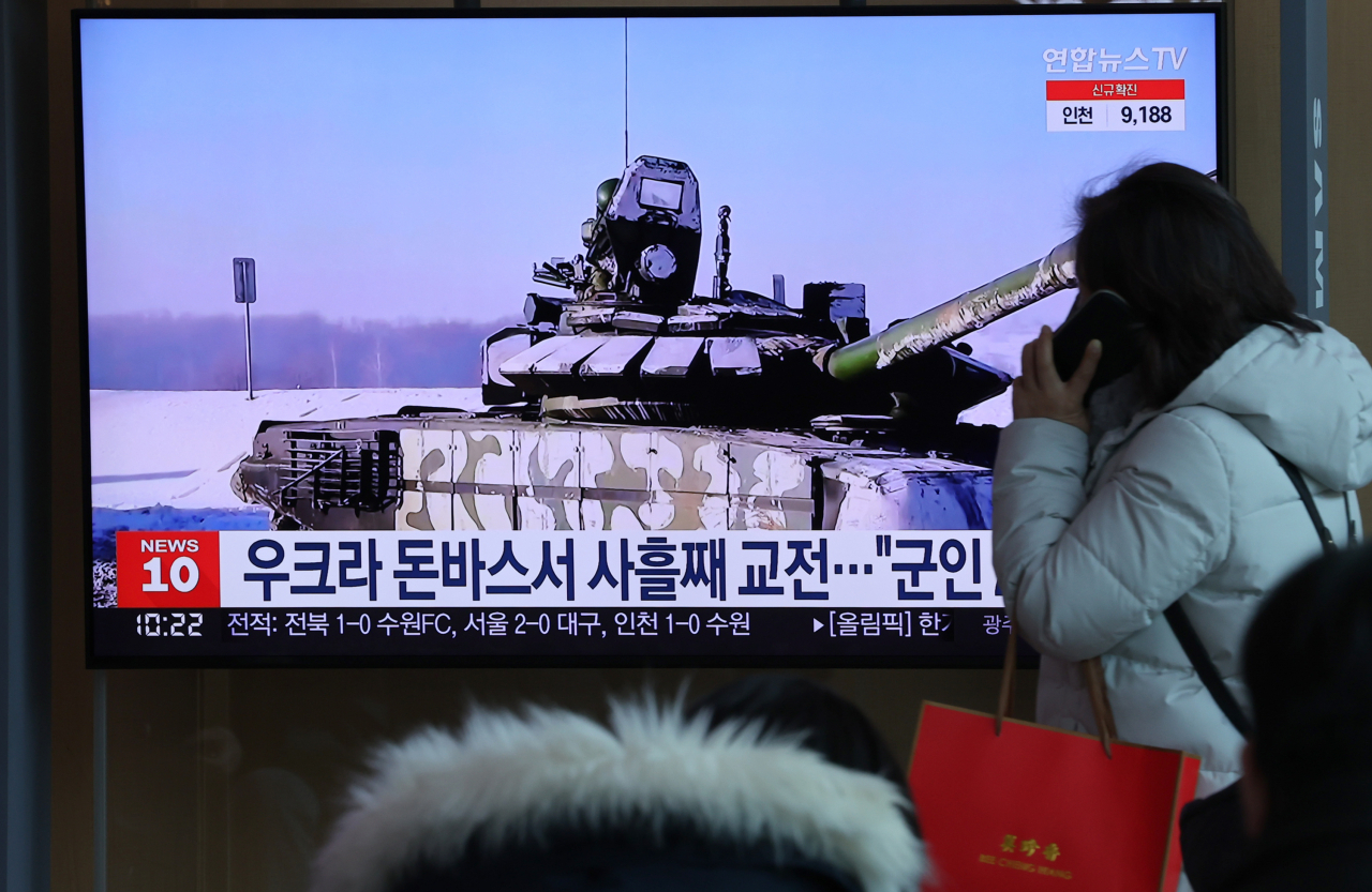 People watch a TV news report on the Ukraine crisis at Seoul Station in central Seoul on Sunday. (Yonhap)