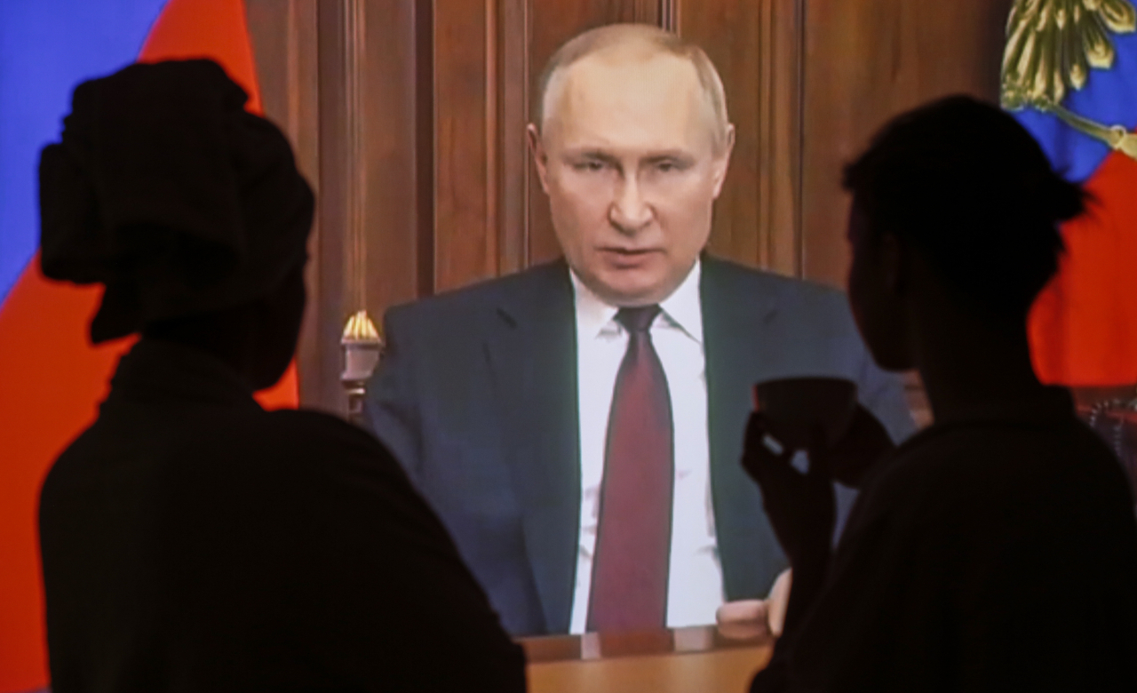 Russian people watch a special televised address by Russian President Vladimir Putin about authorising a special military operation in the Ukrainian Donbass region in Moscow, Russia, on Thursday. Putin announced that the aim is to demilitarize and denazify Ukraine, as well as bring to justice those who committed numerous bloody crimes against civilians. Martial law has been introduced in Ukraine, and explosions are heard in many cities, including Kiev. (EPA-Yonhap)
