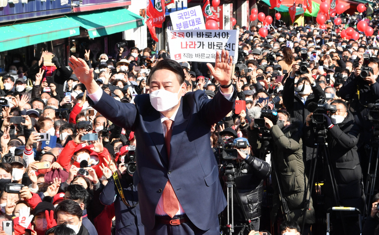 국민의힘 윤석열 대선 후보가 24일 오후 경기도 수원시 팔달문 앞에서 열린 수원 집중유세에서 두 손을 들어 지지자들의 환호에 답하고 있다. 연합뉴스