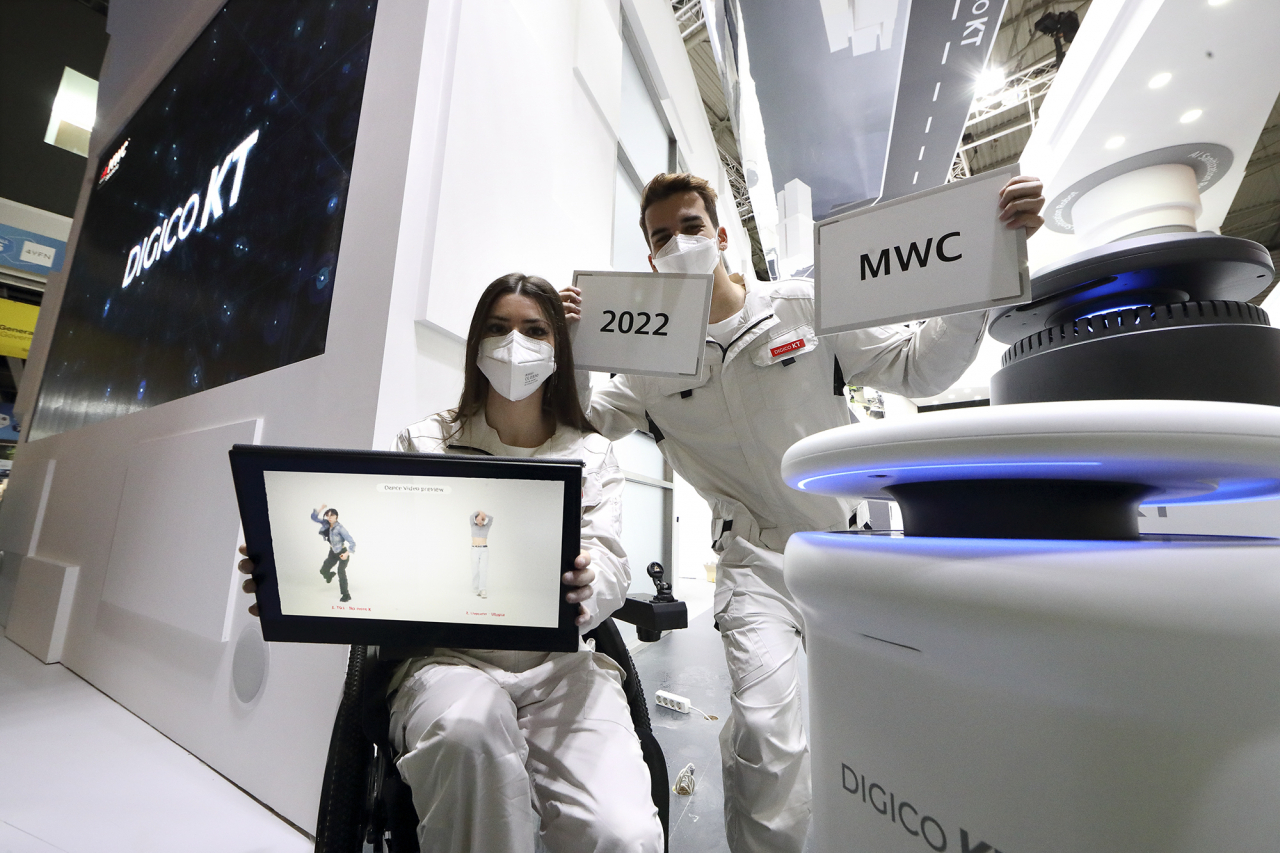 KT가 28일부터 3월 3일(현지시간)까지 스페인 바르셀로나에서 열리는 MWC 2022에서 ‘디지털혁신의 엔진, DIGICO KT’를 주제로 전시관을 선보인다. 현지 도우미들이 KT 전시관에서 인공지능(AI) 방역로봇, 리얼댄스 등 KT의 AI, 로봇 서비스를 소개하고 있다. [KT 제공]