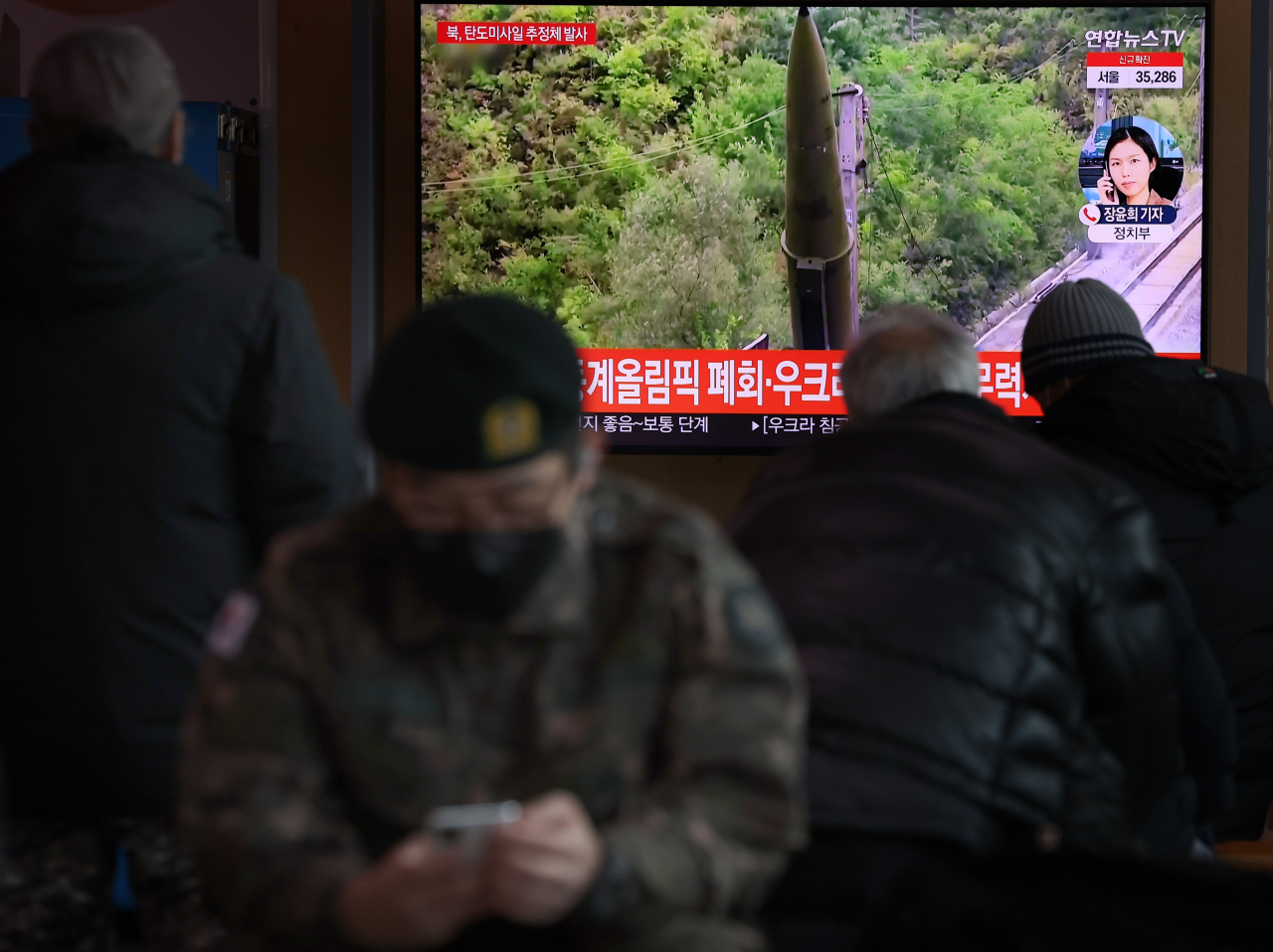 27일 오전 서울역 대합실에 시민들이 북한 탄도미사일 추정 발사체 발사 뉴스를 시청하고 있다. [연합]